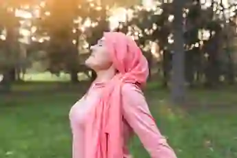 一个戴着粉红色头巾的女人在外面深吸一口气