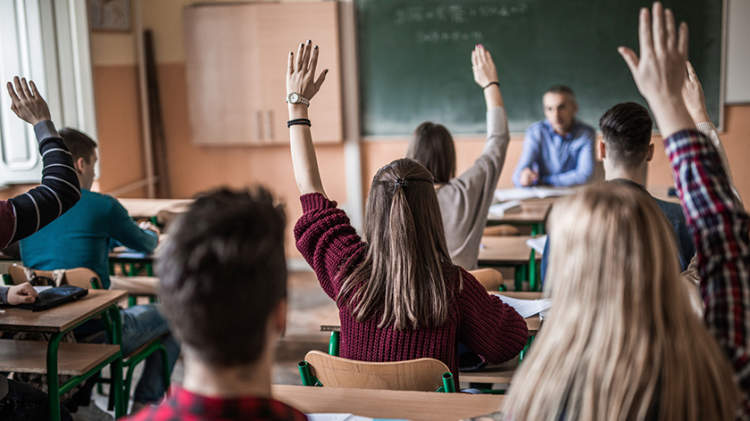 学生提高他们的手在一个高中班。