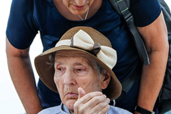 女人帮助年迈的母亲在轮椅上的形象。