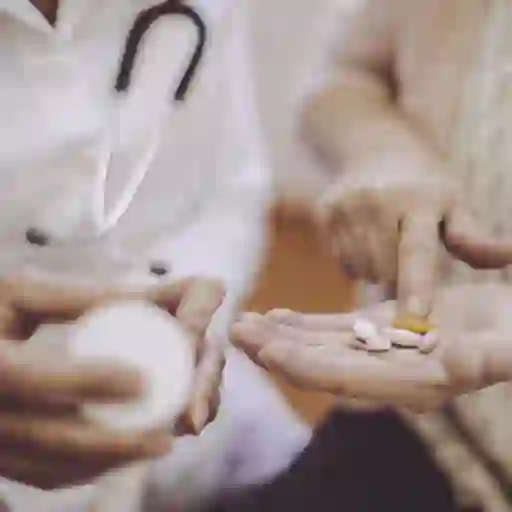 医生拿着药瓶，病人的手拿着药片