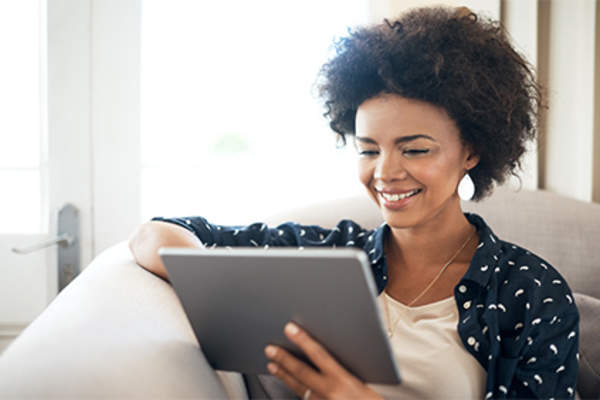 女人在家里用平板电脑看电影。