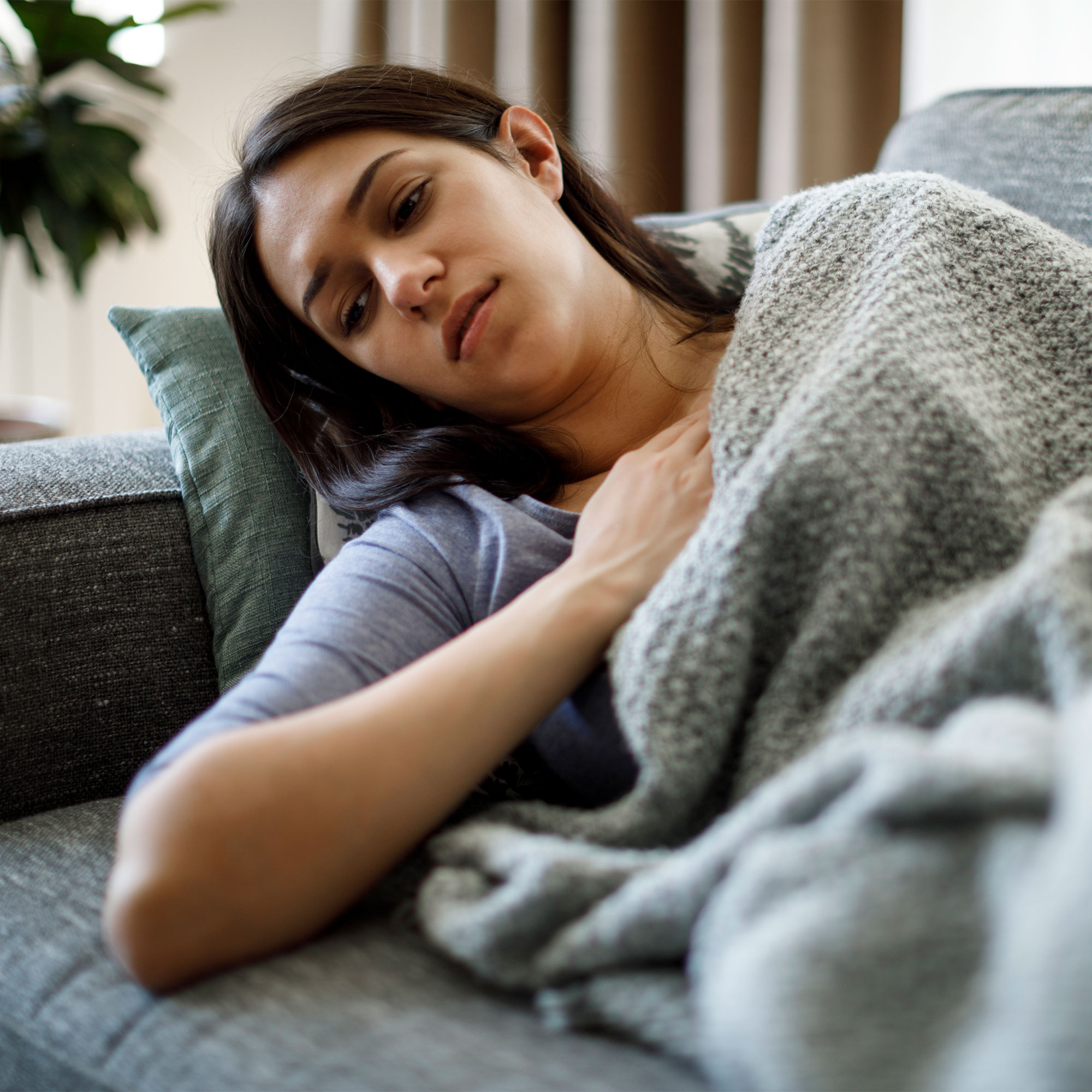 一个生病的女人躺在沙发上