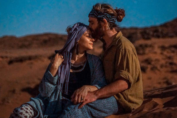 夫妇在沙漠里，女人戴着头巾