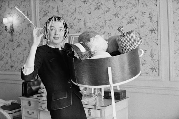 美国女演员Rosalind Russell拿着一系列帽子,1958年8月22日