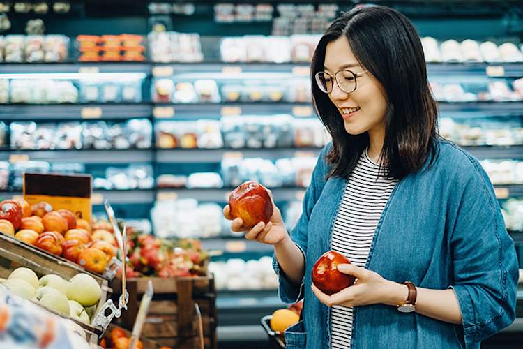 女人逛街买苹果。