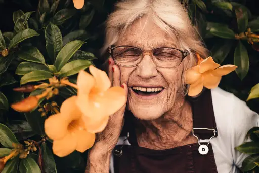 在花丛旁笑着的年长女人