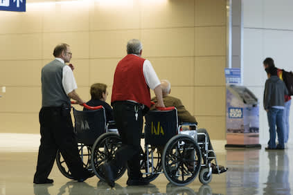 机场员工帮助老夫妇登机区。