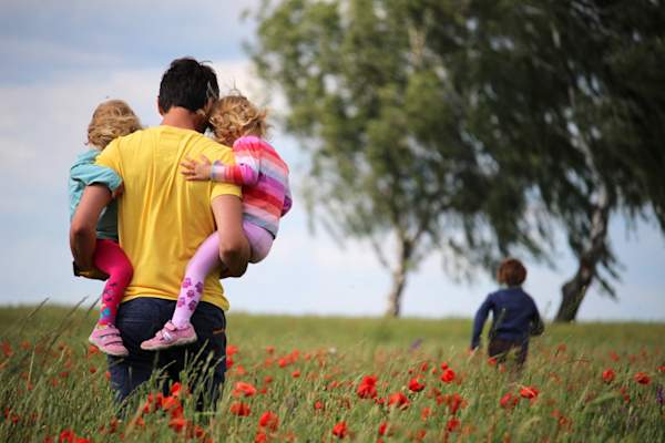 Man walking through flowers with his children