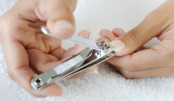 用指甲剪剪指甲的人。