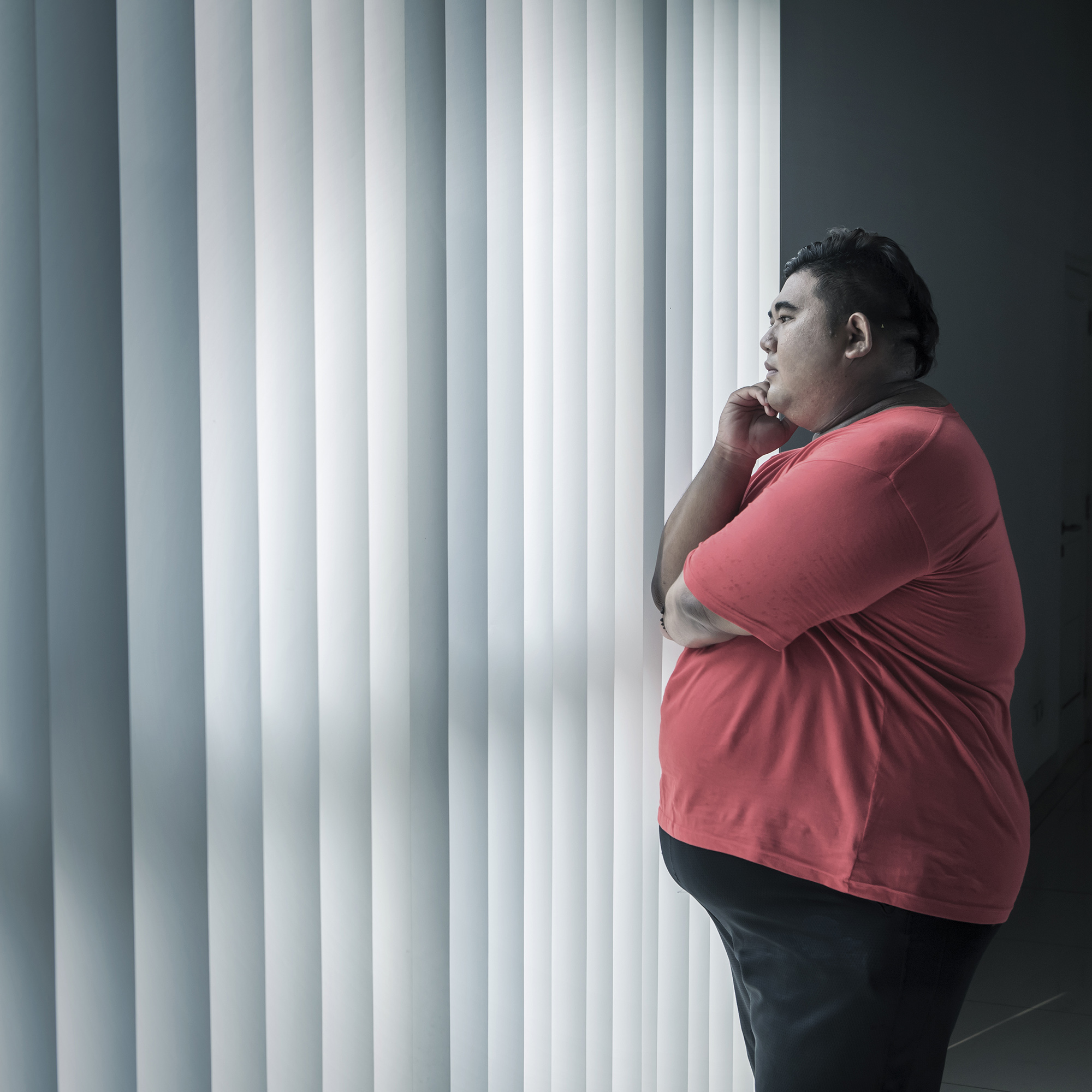 年轻的超重男子想什么，而看着窗外