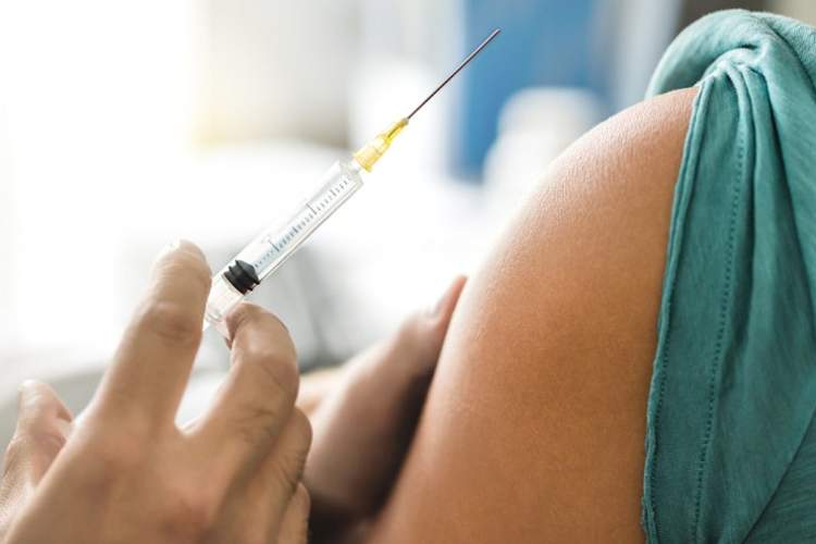 医生或护士给予疫苗接种和抗HPV与注射器