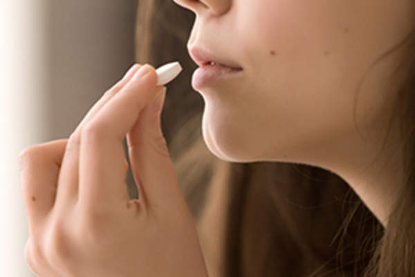 年轻女子服用止痛药。