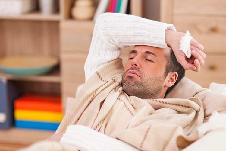 患流感的人躺在沙发上。
