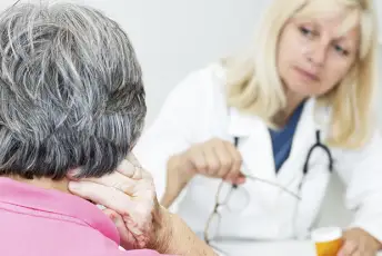一位年长的妇女和她的医生谈论颈部疼痛。