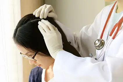 医生正在检查病人的头皮。