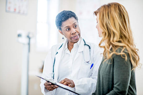 Woman discussing her rheumatoid arthritis flares with her doctor.