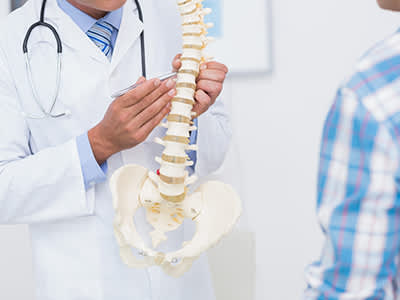 医生给他的病人展示解剖用的脊椎