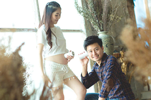 一对带着未出生婴儿的顽皮的年轻夫妇。