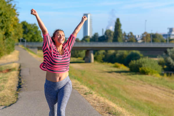 快乐的女人在自行车道上锻炼。