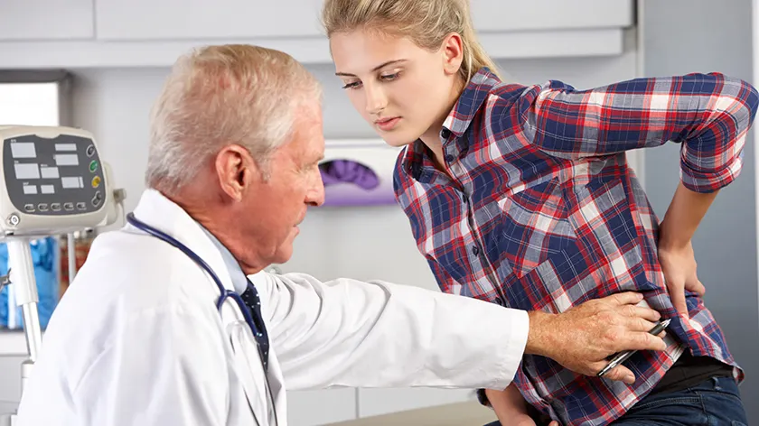 医生检查病人是否有强直性脊柱炎的可能症状。