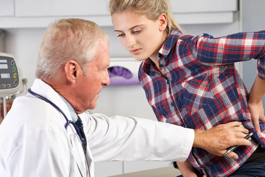 医生检查病人是否有强直性脊柱炎的可能症状。