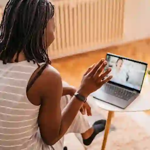 一名妇女正在笔记本电脑上参加远程保健预约。