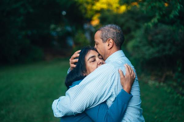 man hugging woman, eyes closed