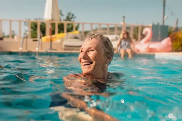 高级女人在游泳池中微笑