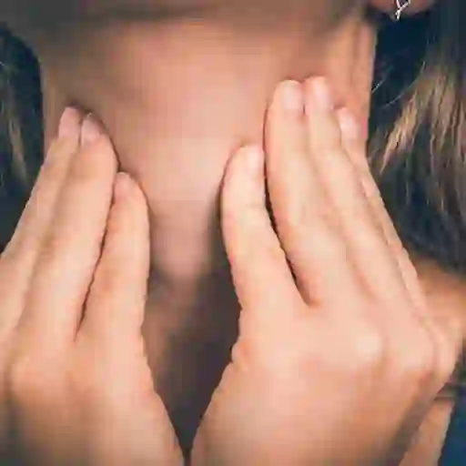 女性触摸喉咙/甲状腺