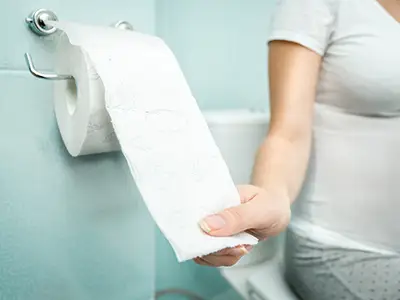 女人拉厕纸的图像。