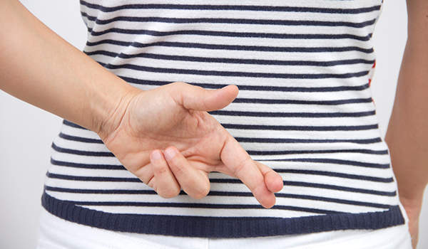 女子与交叉她身后背的手指蓝白条纹衬衫。