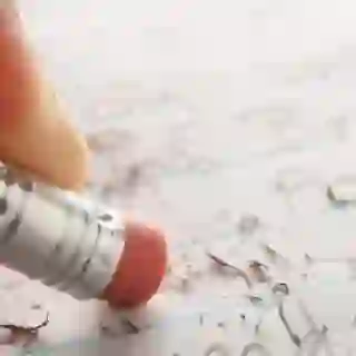 close up of hand erasing pencil
