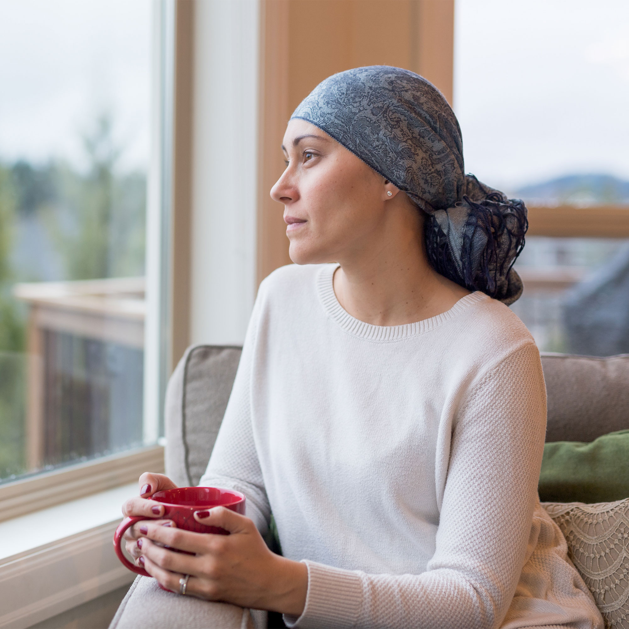 一个女人拿着一个杯子，看着窗外