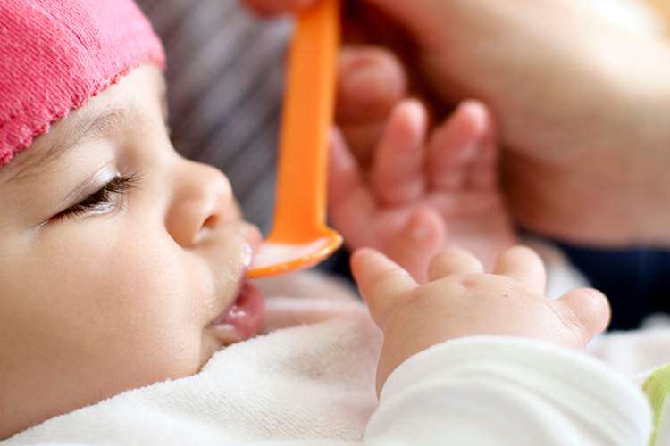 年轻的婴儿吃第一个固体食物。