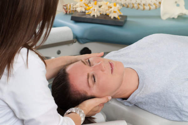 接受脊椎指压按摩师矫正颈部的妇女。