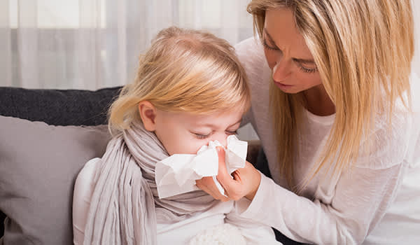 母亲帮生病的女儿擤鼻涕。