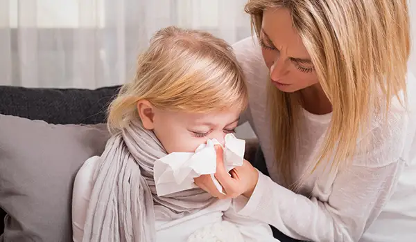 母亲帮助生病的女儿擤鼻涕。