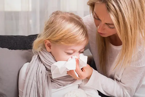 母亲帮助生病的女儿擤鼻涕。