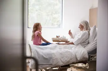 女人在床上和小女孩说话。