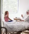 妇女在床上谈话与女孩。