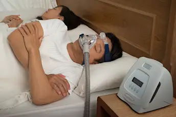 睡眠呼吸暂停的男人在睡觉时使用CPAP机。