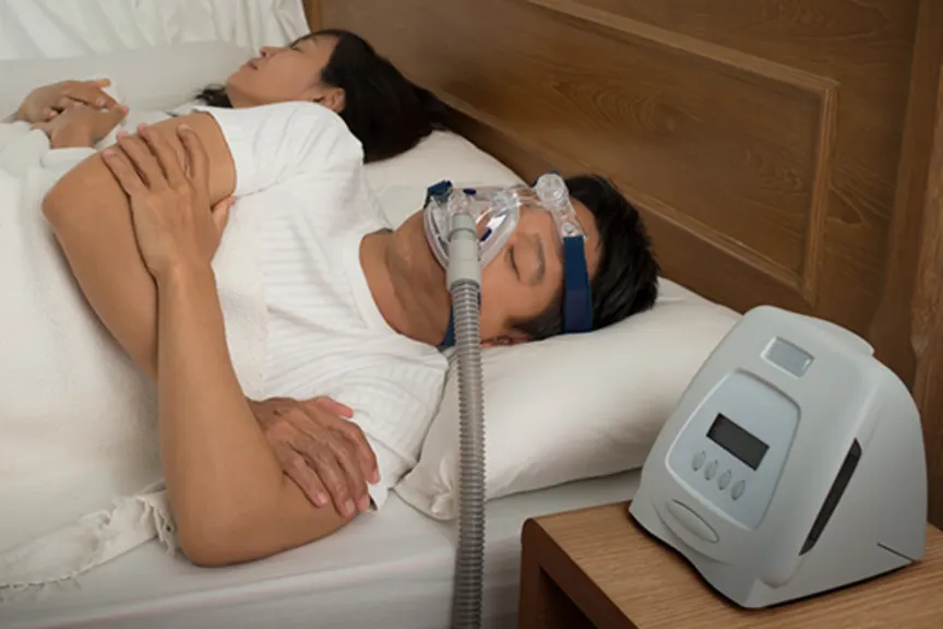 患有睡眠呼吸暂停的男子在睡觉时戴着CPAP机器。