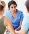 女性医生谈话与母亲和青少年的女孩。