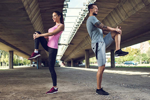 一对夫妇单腿站立,伸展身体保持平衡。