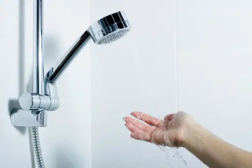 女人在用手测试淋浴头下的水
