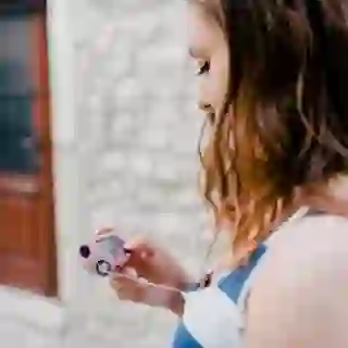 Young diabetic woman holding an insulin pump in the city