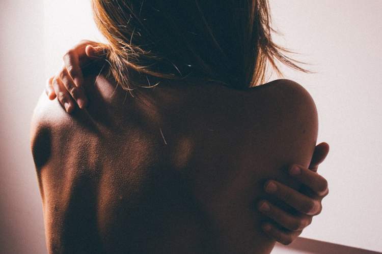 女人赤裸的后背,紧握的双手