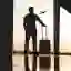 silhouette of man with suitcase looking at plane