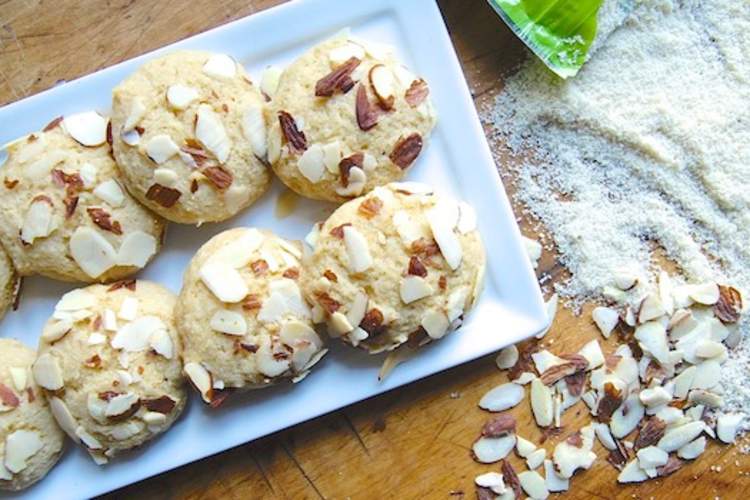 盘子里的无麸质甜饼,杏仁粉洒在木桌上。