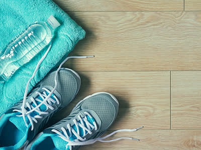 运动鞋，一条毛巾和一瓶水在地板上。